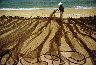 Man laying out fishing nets on bank of the Dingun River, Malaysia, Southeast Asia, Asia