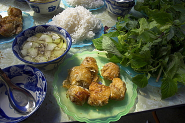 Traditional spring rolls accompanied by vegetable soup, rice noodles and fresh mint and lettuce as side dishes, Nem Ran, Hanoi, Vietnam, Indochina, Southeast Asia, Asia