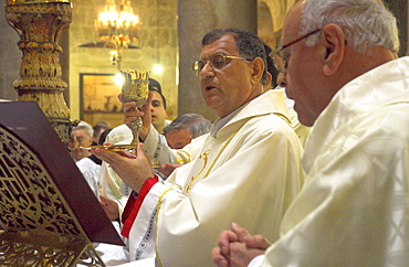 Monseigneur Fouad Boutros Tawal, Coadjutor of the Latin Patriarch of Jerusalem, raising a cup of wine during Mass in Easter week, Church of the Holy Sepulchre, Old City, Jerusalem, Israel, Middle East