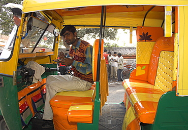 Rickshaw owner sitting in his newly decorated moto rickshaw, Agra, Uttar Pradesh state, India, Asia