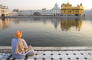 Sikh pilgrim sitting by holy pool, Golden Temple, Amritsar, Punjab state, India, Asia