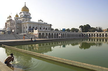 Sikh pilgrim bathing in the pool of the Gurudwara Bangla Sahib temple, Delhi, India, Asia