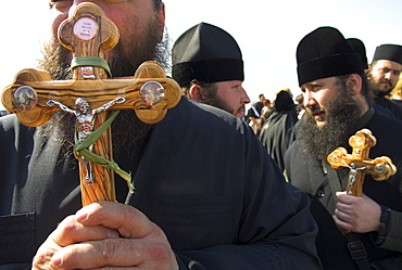 Priests in black holding olive wood crosses in procession to the River Jordan during Christian Orthodox ceremony at Epiphany, Qasr el Yahud, Israel, Middle East