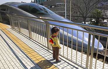 Young child on platform looking at train, Shin Yokohama Shinkansen station, Kansai, Honshu, Japan, Asia