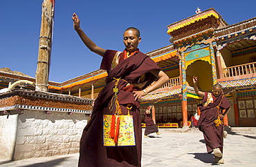 Group of monks dancing in the monastery courtyard rehearsing for Hemis festival, Hemis, Ladakh, India, Asia