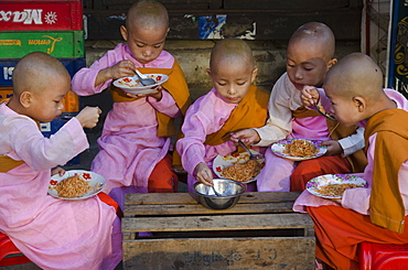 Young novice nuns having their breakfast in the streets of Yangon, Myanmar (Burma), Asia