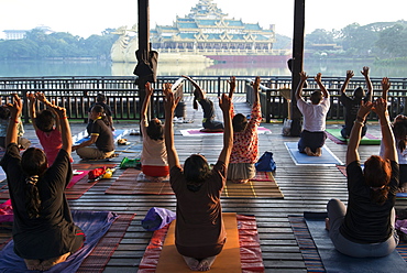 Morning exercices in Kandogyi park with Karaweik hall in background, Yangon (Rangoon), Myanmar (Burma), Asia