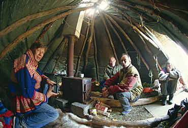 Sami man (Lapplander) inside laavo (tent), drinking moonshine, Finnmark, Norway, Scandinavia, Europe