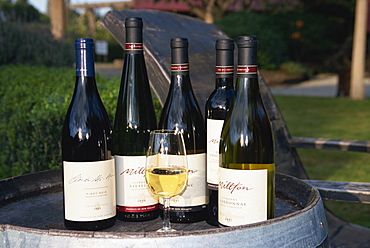 Glass and bottles of wine on barrel, Millton Vineyard, Gisborne, North Island, New Zealand, Pacific