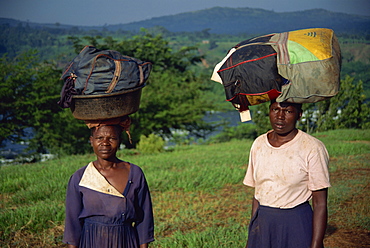 Heavy loads of washing carried on head to be washed in river, Uganda, East Africa, Africa