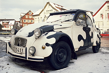 2CV car painted crazy cow, covered in snow