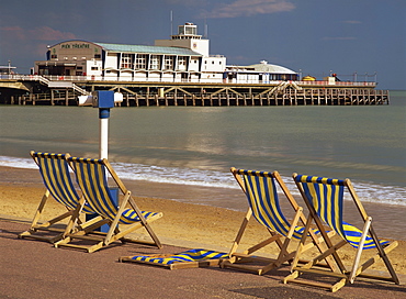 Deckchairs on the Promenade overlooking the deserted beach and Pier Theatre early in the summer season, West Cliff, Bournemouth, Dorset, England, United Kingdom, Europe