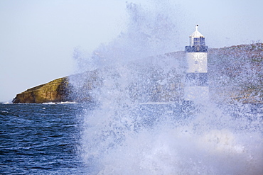 Penmon Point Lighthouse, built in 1838 at the northern entrance to the Menai Strait, and Puffin Island, with rough sea at high tide in winter, Penmon, Anglesey, Wales, United Kingdom, Europe