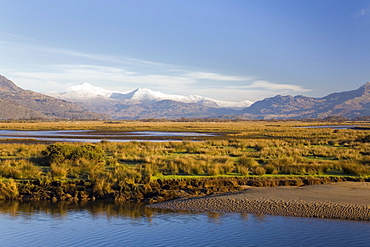 Afon Glaslyn River and Glaslyn Marshes, Site of Special Scientific Interest, with snow on mountains of Snowdon Horseshoe in winter, Porthmadog, Gwynedd, North Wales, United Kingdom, Europe