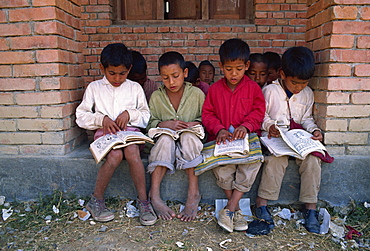 Portrait of a group of local boys reading books at the Save the Children funded school at Chataura, Nepal, Asia