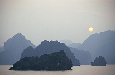 Sunset against limestone grotto islands, Halong Bay, Vietnam, Indochina, Southeast Asia, Asia