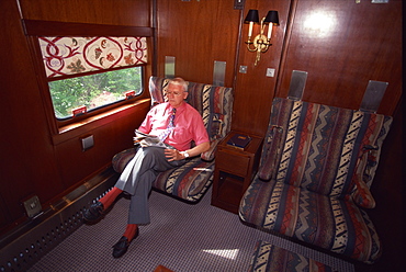 Passenger relaxing in his cabin on the American Orient Express train, travelling in the Southwest U.S., United States of America, North America