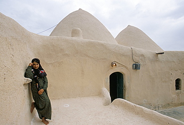 Jinar, 15 year old girl in front of a 200 year old beehive house in the desert, Ebla area, Syria, Middle East