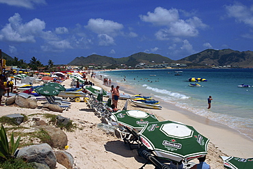 Tourists on loungers under parasols or beach umbrellas on Orient Beach, St. Maarten (St. Martin), Leeward Islands, French West Indies, Caribbean, Central America