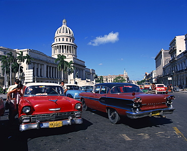 Street scene of old American automobiles used as taxis parked near the Capitolio Building in Central Havana, Cuba, West Indies, Central America