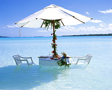 White table, chairs and parasol in the ocean, Bora Bora (Borabora), Tahiti, Society Islands, French Polynesia, South Pacific Islands, Pacific