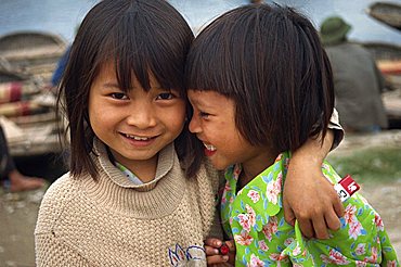 Head and shoulders portrait of two little Vietnamese girls, smiling, one looking at the camera, in Hoa Lu, Vietnam, Indochina, Southeast Asia, Asia