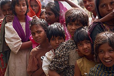 Head and shoulders portrait of a group of Bangladeshi children, looking at the camera, queueing for subsidised rice in Bangladesh, Asia