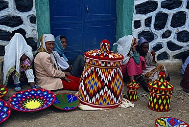 Group of people selling traditional Injera tables, brightly coloured goods, in Gondar Market, Ethiopia, Africa