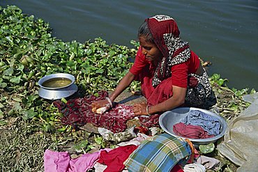 A Bangladeshi woman washing clothes beside the river in Dhaka (Dacca), Bangladesh, Asia