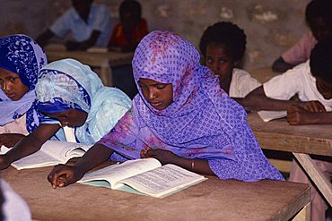 Portrait of school children sitting at tables, reading in a school classroom, Somalia, Africa