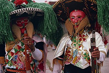 Portrait of two men wearing masks, costumes, sombreros and carrying guns, during the Huejotzingo Carnival in Mexico, North America