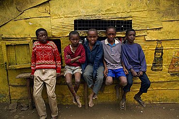 Portrait of a group of five boys, slum children, sitting on a bench outdoors, looking at the camera, Kariobangi, Nairobi, Kenya, East Africa, Africa