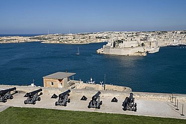 Cannon in Barracca Gardens, Fort St. Angelo across the water, Valletta, Malta, Mediterranean, Europe