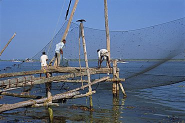 Man operating large Chinese fishing nets at Fort Cochin, Kerala, India, Asia