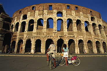 Couple admiring the Colosseum on bike ride, Rome, Lazio, Italy,Europe