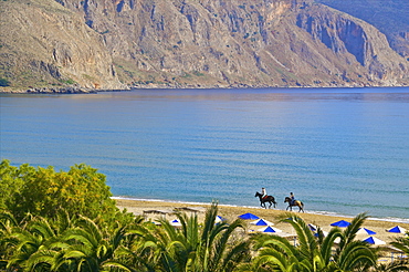 Two tourists riding horses on the beach, Giorgioupolis, Crete, Greek Islands, Greece, Europe