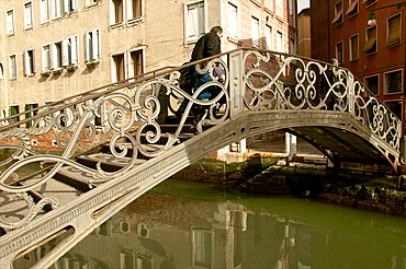 Exceptional metal bridge over canal with water reflections, and pedestrian, Venice, UNESCO World Heritage Site, Veneto, Italy, Europe