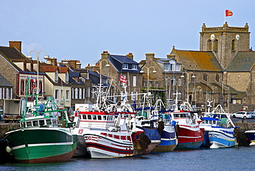 Fishing boats and harbour, and 17th century church in the background, Barfleur, one of the loveliest French village, Cotentin, Normandy, France, Europe