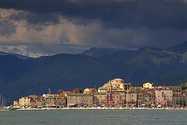 Dark clouds over hills and the skyline of the town of St. Florent on Cap Corse on the island of Corsica, France, Mediterranean, Europe