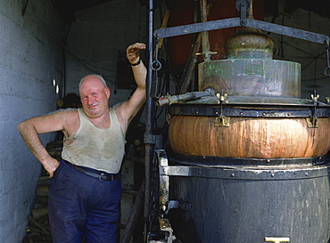 Man with alembique spirit still, Western Loire, France, Europe