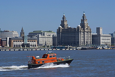 View of the Liverpool skyline and the Liver building, with a pilot boat in the foreground, taken from the Mersey ferry, Liverpool, Merseyside, England, United Kingdom, Europe