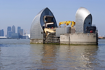 The Thames Barrier with Canary Wharf behind, London, SE18, England, United Kingdom, Europe