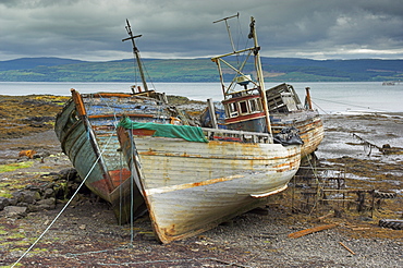 Wrecked fishing boats in gathering storm, Salen, Isle of Mull, Inner Hebrides, Scotland, United Kingdom, Europe