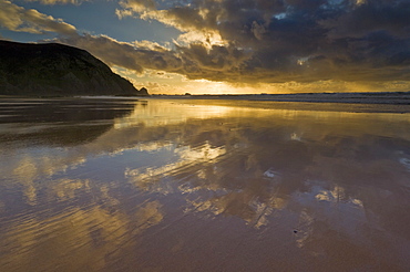 Sunset reflected in tidal wash, Praia do Castelejo beach near Vila do Bispo, Algarve, Portugal, Europe