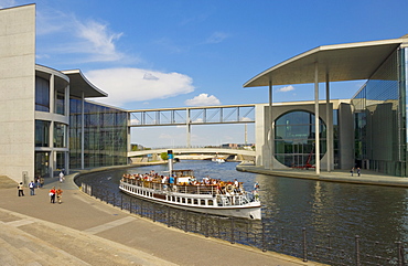 Tourist cruise boat on the river Spree passing the Marie-Elizabeth-Luders Haus and Paul-Lobe-Haus part of the German Bundestag building complex, Berlin, Germany, Europe