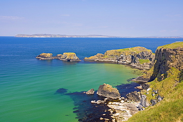 Carrick Island in Larrybane Bay, with a limestone headland, and Rathlin Island in the background, on the North Antrim Causeway Coast Way, County Antrim, Ulster, Northern Ireland, United Kingdom Europe