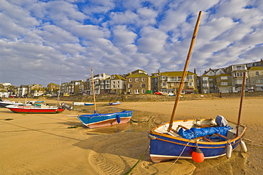 Strange cloud formation in the early morning with small Cornish fishing boats at low tide in the harbour at St. Ives, Cornwall, England, United Kingdom, Europe