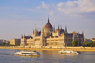 The neo-gothic Hungarian Parliament building, designed by Imre Steindl, UNESCO World Heritage Site, with cruise boats on the River Danube in the foreground, Budapest, Hungary, Europe