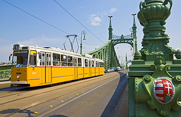 Yellow tram on The Liberty Bridge (Szabadsag hid), over the Rver Danube, Vamhaz Korut street, Budapest, Hungary, Europe