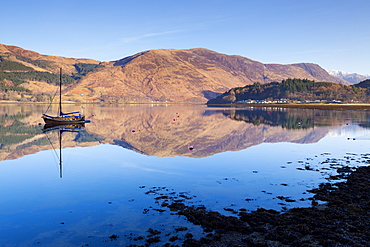 Picturesque tranquil Loch Leven with sailing boat and reflection from Glen Coe village, Highlands, Scotland, United Kingdom, Europe